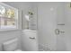A modern bathroom features a tiled shower with glass door, gold fixtures, and a toilet at 2324 Orange Tree Dr, Edgewater, FL 32141