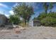 Spacious backyard with a storage shed, gravel landscaping, and mature trees providing ample shade at 2548 Crestwood Ave, New Smyrna Beach, FL 32168