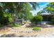 Landscaped backyard featuring gravel, mature trees, and a shed, with ample space for outdoor activities at 2548 Crestwood Ave, New Smyrna Beach, FL 32168