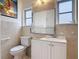 Cozy bathroom featuring a white vanity, toilet, a large mirror, and tiled walls at 255 Lexington Dr, Daytona Beach, FL 32114