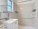 Full bathroom with a white vanity, large mirror, tiled walls, and safety features at 255 Lexington Dr, Daytona Beach, FL 32114