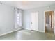 An airy bedroom featuring light-colored walls, natural light, and a door to the hallway at 255 Lexington Dr, Daytona Beach, FL 32114