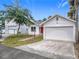 Exterior view of waterfront home featuring a brick walkway, lush landscaping, and attached two-car garage at 255 Lexington Dr, Daytona Beach, FL 32114