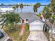 Charming waterfront home with a brick walkway, attached garage, and a view of the bay and city skyline at 255 Lexington Dr, Daytona Beach, FL 32114