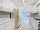 Eat-in kitchen with view to sunroom, featuring white cabinets and mosaic backsplash at 255 Lexington Dr, Daytona Beach, FL 32114