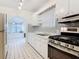 Galley kitchen featuring white cabinetry, patterned backsplash, and black and white tiled floors at 255 Lexington Dr, Daytona Beach, FL 32114