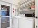 Well-lit laundry area with a washer, dryer, shelving, and an exterior door at 255 Lexington Dr, Daytona Beach, FL 32114