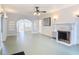 Spacious living room with fireplace, archways and shelving, and decorative ceiling fan at 255 Lexington Dr, Daytona Beach, FL 32114
