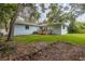 Spacious backyard featuring a wooden deck and lush greenery at 2617 Pine Tree Dr, Edgewater, FL 32141