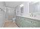 This bathroom features double sinks, mirrors, and walk-in shower with glass doors at 2617 Pine Tree Dr, Edgewater, FL 32141