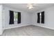 Neutral bedroom with light-gray paint, ceiling fan, light-wood-look flooring, black curtains and white trim at 2617 Pine Tree Dr, Edgewater, FL 32141