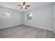 This bedroom features a ceiling fan and hardwood flooring and windows covered with blinds at 2617 Pine Tree Dr, Edgewater, FL 32141