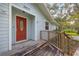 Inviting front porch with wood deck and red front door, perfect for relaxing at 2617 Pine Tree Dr, Edgewater, FL 32141