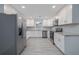 Bright kitchen features stainless appliances, white cabinets, modern backsplash, and tile flooring at 2617 Pine Tree Dr, Edgewater, FL 32141