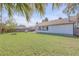 Private backyard with a fire pit and chicken coop features a large lawn, ideal for relaxation and outdoor activities at 2715 Pine Tree Dr, Edgewater, FL 32141