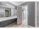Bathroom with a long vanity and mirror featuring an open door to the tiled shower at 2715 Pine Tree Dr, Edgewater, FL 32141