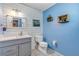 Stylish half bath with shiplap accent wall, updated vanity and blue paint at 2715 Pine Tree Dr, Edgewater, FL 32141