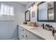 Bright bathroom features dual sinks, modern lighting fixtures, and framed mirrors at 2715 Pine Tree Dr, Edgewater, FL 32141