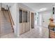 Light and bright hallway features decorative closet doors and access to the staircase at 2715 Pine Tree Dr, Edgewater, FL 32141