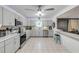Updated kitchen with stainless steel appliances, gray cabinets, and bar seating at 2715 Pine Tree Dr, Edgewater, FL 32141