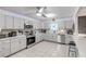 Bright kitchen featuring stainless steel appliances, gray cabinets, and a breakfast bar at 2715 Pine Tree Dr, Edgewater, FL 32141