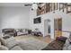Vaulted living room features laminate flooring, sofas, and an open loft at 2715 Pine Tree Dr, Edgewater, FL 32141