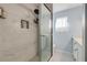 Contemporary shower with a glass door, white marble tile, and a rainfall shower head at 2715 Pine Tree Dr, Edgewater, FL 32141