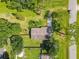 An aerial view showing mature trees surround a cozy home featuring a sprawling lawn and mature landscaping at 3045 Pine Tree Dr, Edgewater, FL 32141