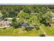 Aerial view of a lovely home featuring a long driveway, carport, mature trees and a manicured lawn at 3045 Pine Tree Dr, Edgewater, FL 32141