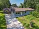 An aerial view of a single-story home with a spacious yard and covered carport at 3045 Pine Tree Dr, Edgewater, FL 32141