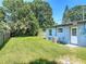 A spacious, grassy backyard featuring a light-blue house and a wooden fence with lots of privacy at 3045 Pine Tree Dr, Edgewater, FL 32141
