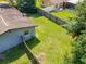 Aerial view of a well-maintained backyard, wooden fence, and light-blue house with mature trees at 3045 Pine Tree Dr, Edgewater, FL 32141