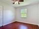 Cozy bedroom featuring hardwood floors, a ceiling fan, and a window providing natural light and a view at 3045 Pine Tree Dr, Edgewater, FL 32141