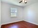 This bedroom offers natural light with hardwood floors, and a ceiling fan, perfect for relaxation at 3045 Pine Tree Dr, Edgewater, FL 32141