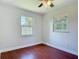 Bedroom with hardwood floors, two windows offering natural light, and a neutral color scheme at 3045 Pine Tree Dr, Edgewater, FL 32141