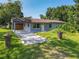 Single-story home with covered parking, nestled in a green landscape at 3045 Pine Tree Dr, Edgewater, FL 32141