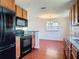 Updated kitchen with stainless steel appliances, granite countertops, and ample cabinet space, flowing into the dining area at 3045 Pine Tree Dr, Edgewater, FL 32141