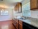 Bright kitchen features granite countertops, updated cabinets, and stainless steel sink beneath a large window at 3045 Pine Tree Dr, Edgewater, FL 32141
