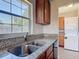 Kitchen featuring granite countertops, stainless steel sink, and a view to laundry area through a large window at 3045 Pine Tree Dr, Edgewater, FL 32141