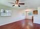 Bright living room with wood floors, multiple windows and chandelier lit dining area at 3045 Pine Tree Dr, Edgewater, FL 32141