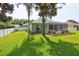 Well-maintained backyard with green lawn, garden beds, and a screened-in patio, perfect for outdoor enjoyment at 3288 Spruce Creek Gln, Port Orange, FL 32128