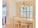 Dining room with a large window and plantation shutters, plus a modern chandelier at 3288 Spruce Creek Gln, Port Orange, FL 32128