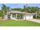 Charming single-story home features a three-car garage, manicured lawn, and mature palm trees at 3288 Spruce Creek Gln, Port Orange, FL 32128