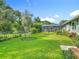 Beautiful backyard with a screened enclosure, a lush green lawn, and mature landscaping at 343 Sweet Bay Ave, New Smyrna Beach, FL 32168