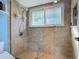 Walk-in shower with light tile, a glass door and window for natural light at 343 Sweet Bay Ave, New Smyrna Beach, FL 32168
