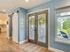Inviting foyer featuring decorative front doors, wood floors, and sliding barn door at 343 Sweet Bay Ave, New Smyrna Beach, FL 32168
