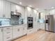 The kitchen features custom white cabinets, stainless appliances, granite countertops, and sleek tile backsplash at 343 Sweet Bay Ave, New Smyrna Beach, FL 32168