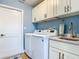Bright laundry room boasts modern washer and dryer, granite countertops, and ample cabinet space at 343 Sweet Bay Ave, New Smyrna Beach, FL 32168