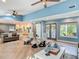 Spacious living room with vaulted ceilings, wood floors, a fireplace, and access to the kitchen at 343 Sweet Bay Ave, New Smyrna Beach, FL 32168