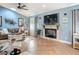 Cozy living room with a modern fireplace, mounted TV, herringbone floors, and bright blue walls at 343 Sweet Bay Ave, New Smyrna Beach, FL 32168